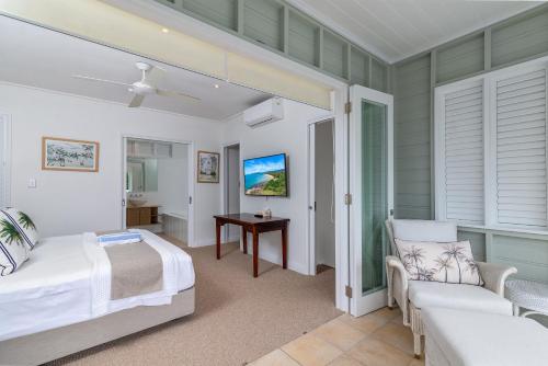 道格拉斯港Seascape Holidays Villas on Murphy Street的一间卧室配有一张床、一张沙发和一张桌子
