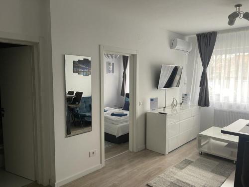 奥拉迪亚Phoenix Luxury Apartment的一间白色客房,配有镜子和一间卧室