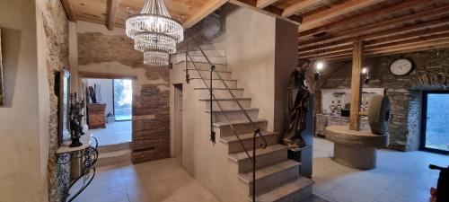 PorriDomaine COLONNA SANTINI ,Chambre d hôtes Piscine, sauna, spa的走廊设有楼梯和吊灯