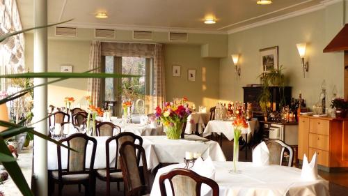默尔恩维森罗斯餐厅及酒店的用餐室配有桌椅和鲜花