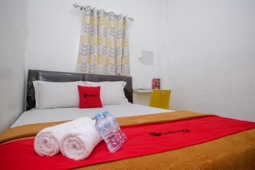 PanikiRedDoorz near Politeknik Manado的一间卧室配有带毛巾的床
