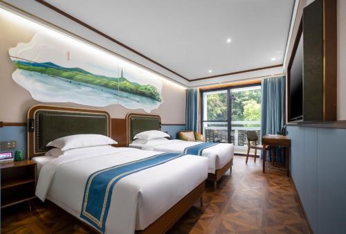 杭州时光漫步S酒店（杭州西湖店）的两张位于酒店客房的床,墙上挂着一幅画