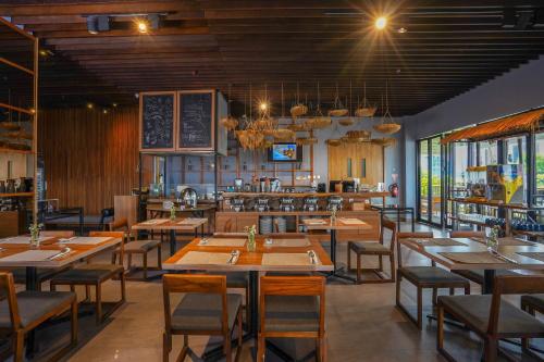 班达楠榜楠榜巴提夸酒店的一间带木桌椅的餐厅和一间厨房