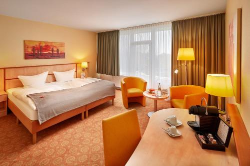 维森豪瑟斯坦德Strandhotel an der Ostsee的酒店客房带一张床、一张桌子和椅子