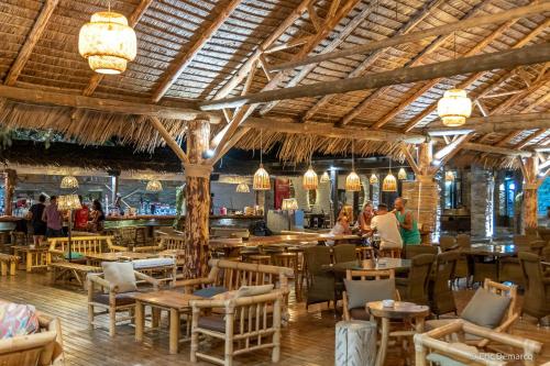 KoundourosPorto Koundouros Beach and Villas的一间带桌椅的餐厅和一间酒吧