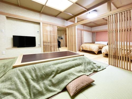 福岛晴海屋日式旅馆的一间卧室配有两张床和一台平面电视