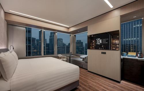 深圳深圳前海JEN酒店,近前海石公园，2400平米健身中心的一间配备有白色床的卧室,享有城市美景。