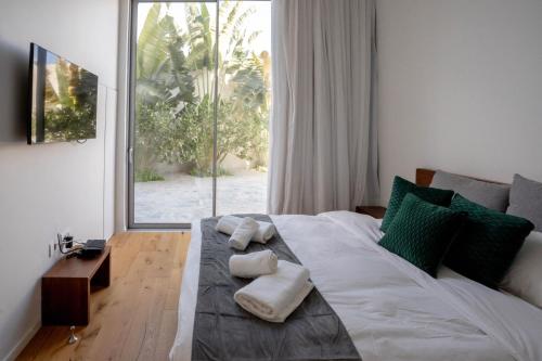 埃拉特YalaRent Red Sea glory villa-private pool & jacuzzi的一间卧室配有一张床,上面有两条毛巾