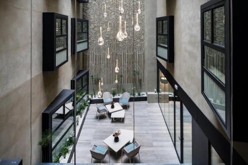 巴塞罗那加泰罗尼亚马达林思酒店的大堂设有吊灯和桌椅
