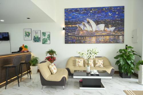 Ấp Rạch MẹoHAPPY HOTEL Kien Giang的客厅配有两张沙发,墙上挂有绘画作品