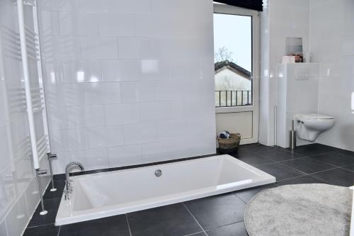 凯尔克拉Villa Aix的带白色浴缸的浴室和卫生间