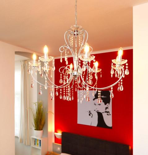 赛巴特班森Villa Anna - Rubin的客厅里的一个吊灯,有一道红色的墙