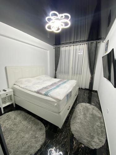 北马马亚-讷沃达里Apartament 105 - HF Building Resort的卧室配有白色的床和2个地毯。