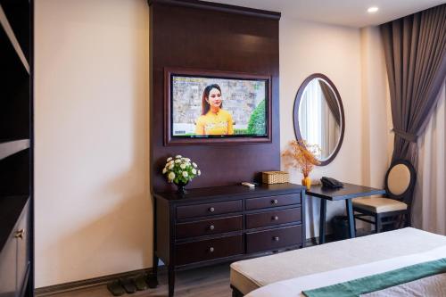 河内Hanoi Center Silk Charming Hotel & Travel的一间卧室配有梳妆台和墙上的电视