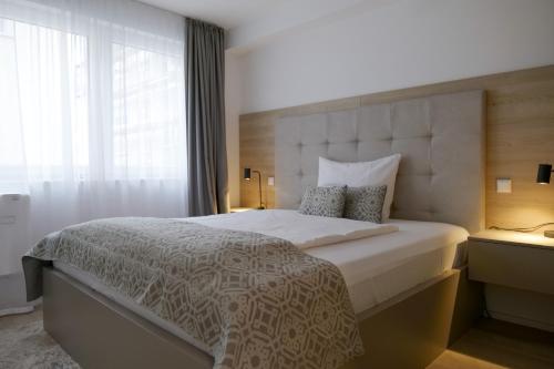斯图加特舒适公寓式酒店的一间卧室设有一张大床和大窗户