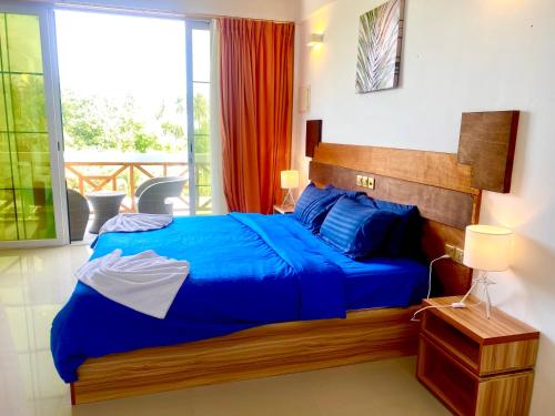 迪古拉Sands Grand Hotel的一间卧室设有蓝色的床和一个阳台