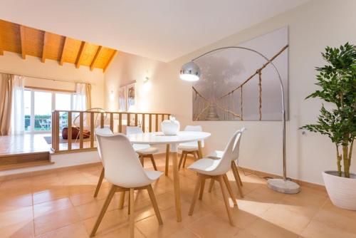 萨格里什Villas T3 com Jardim Vila Sagres的一间设有白色桌子和白色椅子的用餐室