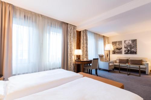 汉堡霍夫汉堡欧洲酒店的酒店客房,设有两张床和一张沙发