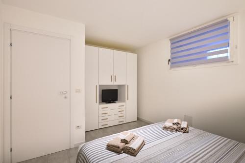阿尔盖罗Corallo House Alghero的一间白色卧室,配有两张床和电视