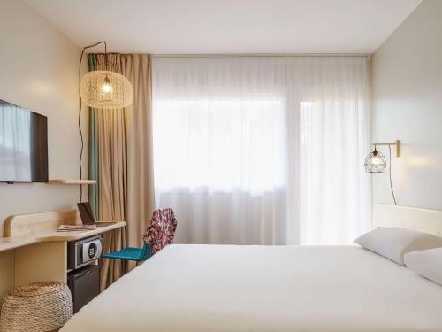 耶尔宜必思萨拉萨海耶若斯海滨酒店的卧室设有一张白色大床和一扇窗户。
