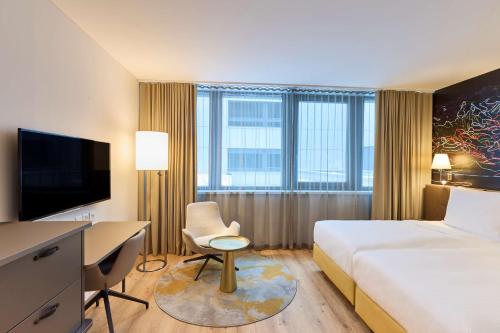 卢塞恩卢塞恩丽笙酒店的酒店客房配有一张床、一张书桌和一台电脑