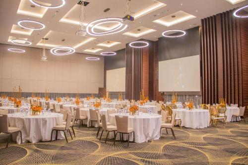 朱巴Radisson Blu Hotel, Juba的一个带白色桌椅的大型宴会厅