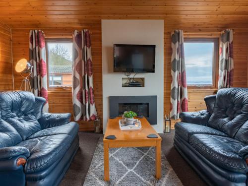 金罗斯Chalet Loch Leven Lodge 12 by Interhome的带沙发、电视和桌子的客厅