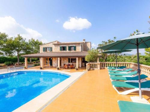 阿尔库迪亚Villa Ca na Fideu by Interhome的一座房子,设有游泳池、椅子和遮阳伞