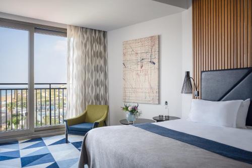 荷兹利亚丹阿卡迪亚荷兹利亚酒店的酒店的客房 - 带一张床、椅子和窗户