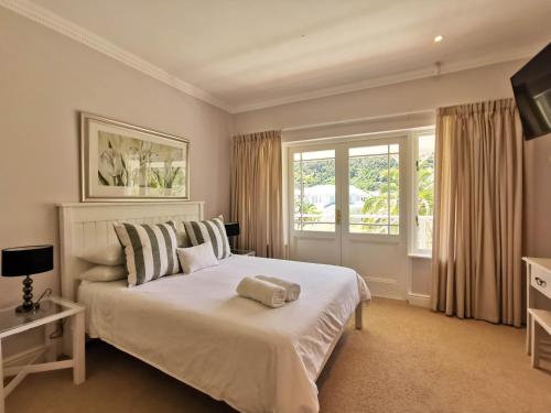 普利登堡湾River Club 4213的卧室设有一张白色大床和一扇窗户。