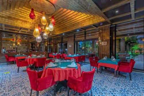 凯麦尔Amara Luxury Resort & Villas的一间设有红色桌子和红色椅子的餐厅