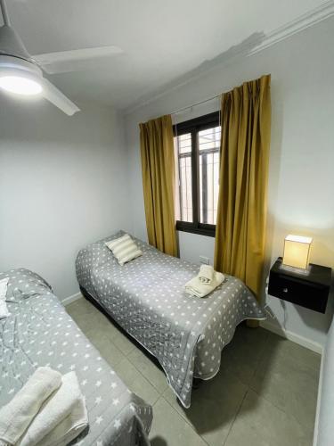 门多萨Hermoso Departamento Azulino的一间卧室设有两张床和窗户。