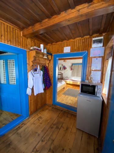 BrebCăsuța Tivadar的一间小房子,有蓝色的门和微波炉
