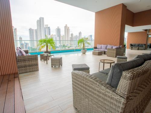 巴拿马城Boutique Apartments Panamá Coco del Mar的大楼内客厅配有沙发和椅子