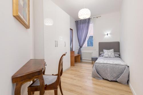 威尼斯里亚托桥豪华公寓的一间卧室配有一张床、一张桌子和一张桌子