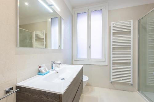 威尼斯里亚托桥豪华公寓的白色的浴室设有水槽和镜子