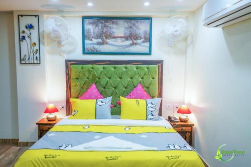 古尔冈Lime Tree Hotel Near 32nd Avenue Sector 29 Gurgaon的一间卧室配有一张带黄色和粉红色枕头的床