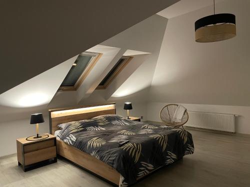 科希切日纳Pogodna Zagroda-Dom na Kaszubach & Strefa Spa的一间卧室配有一张床,楼梯设有天窗