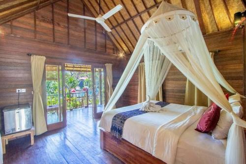 蓝梦岛Garden Cottage Lembongan & Hostel的一间卧室配有一张带蚊帐的床