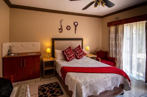 范德拜尔帕克Invite Guest House Self Catering Accommodation的一间卧室配有红色枕头的床