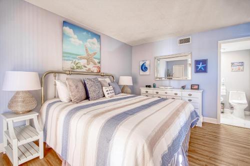 默特尔比奇Sunset Coral的一间蓝色卧室,配有一张床和镜子