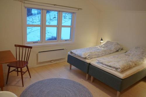 SæbøMoonvalley Lodge - stort & koselig hus - Måndalen的一间卧室设有两张床和窗户。