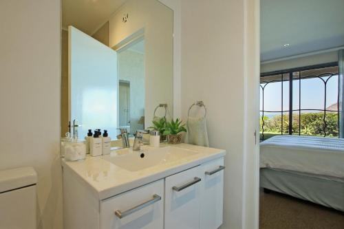 豪特湾9 The Village的一间带水槽和镜子的浴室以及一张床