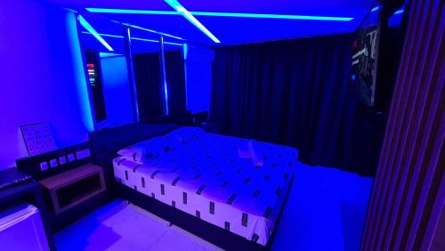 阿雷格里港Sense Motel的配有床和蓝色灯光的房间