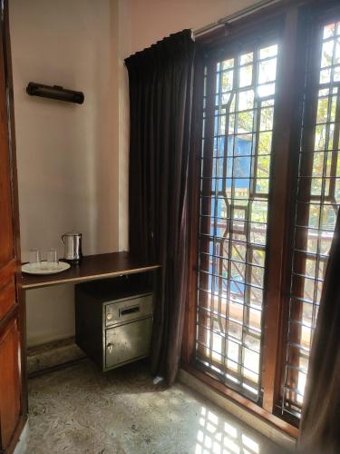 特里凡得琅Sreevalsam Guest House的带桌子和窗户的房间