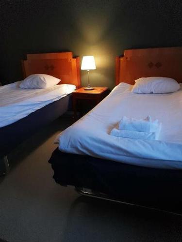 哈格福什Monicas Bed&Breakfast的一间卧室设有两张床和一张桌子上的台灯。