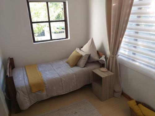 斯泰伦博斯Santika Getaway Cottage Stellenbosch的一间小卧室,配有一张带窗户的床