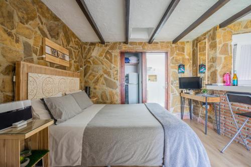 内尔哈内尔哈阳光一室公寓 的一间卧室设有一张床和石墙