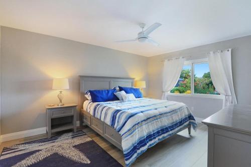马可岛768 Sea Court的一间卧室配有一张带蓝色床单的床和一扇窗户。