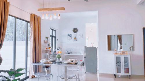 万津My Homestay @ Morib Bay Banting的白色的厨房配有桌子和冰箱